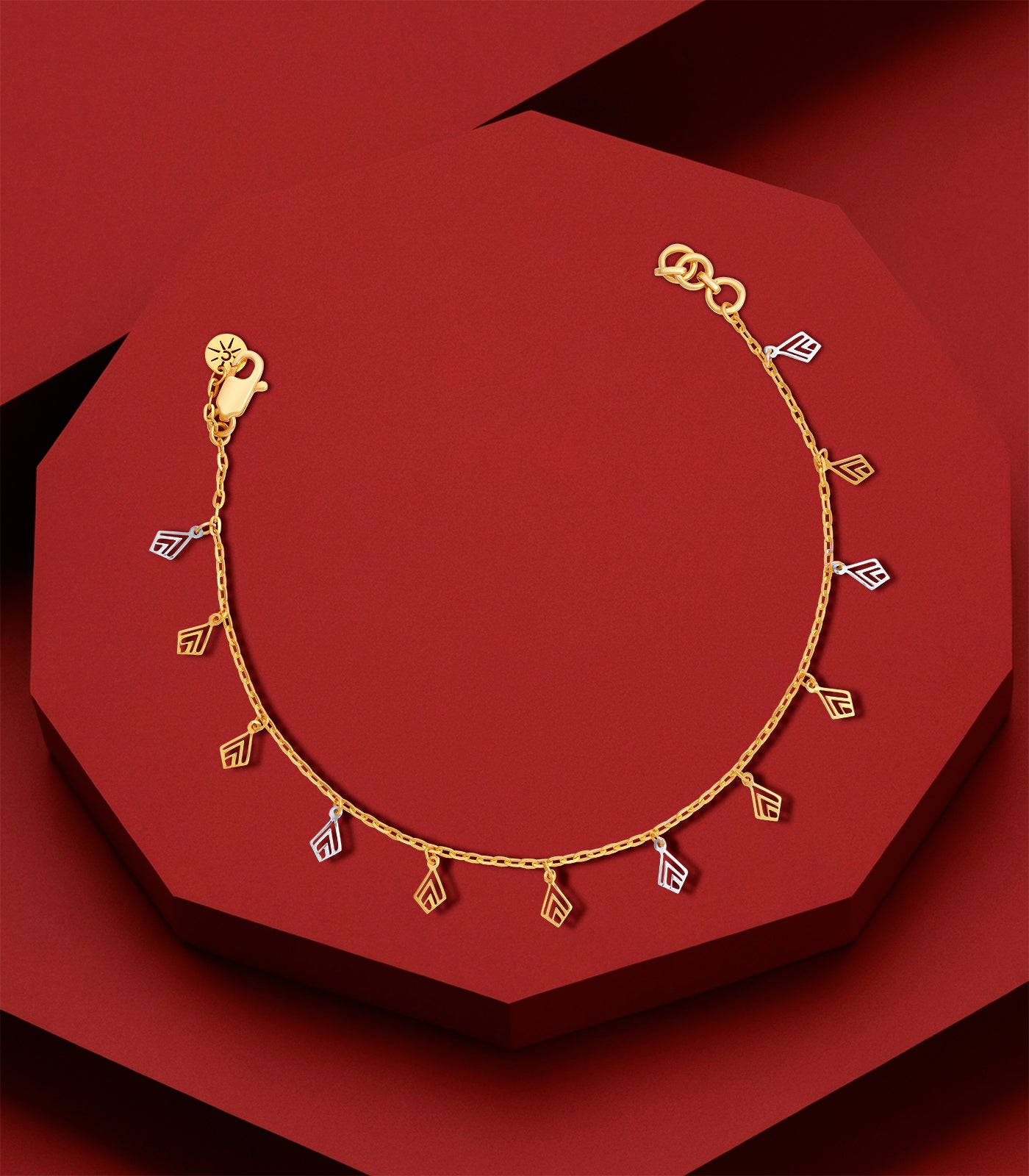 Gold bracelet with geometric charms on a red background